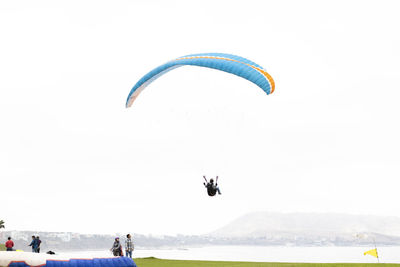 People paragliding over sea against sky