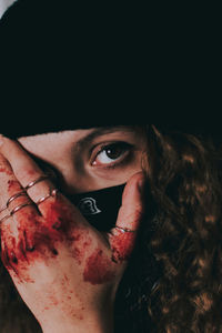 Close-up portrait of young woman covering face