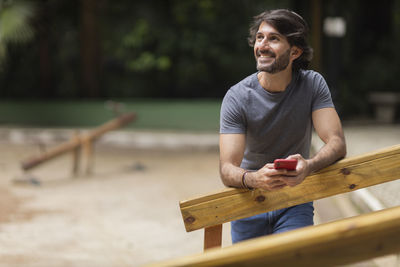 Portrait of man sitting on wood