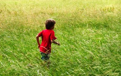 High angle view of boy running on grassy field