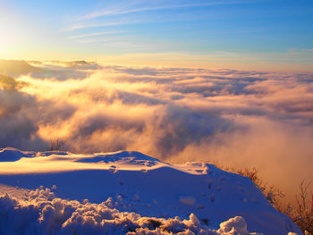 Scenic view of snow covered mountains against sky during sunset