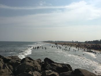 People on beach against blue sky