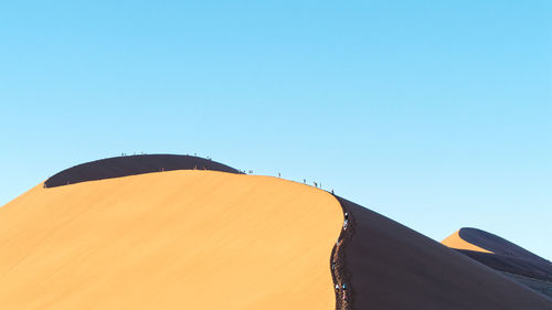 Tent on desert against clear sky