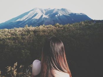 Rear view of woman looking at forest and mountains