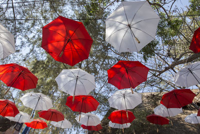 Low angle view of umbrellas hanging against sky