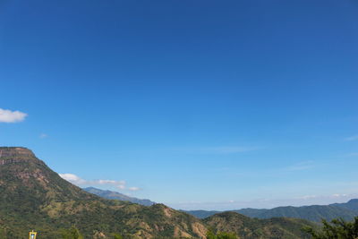 Scenic view of mountains against blue sky