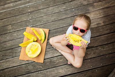 Portrait of young woman wearing sunglasses on table