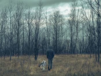 Rear view of woman with dog on field