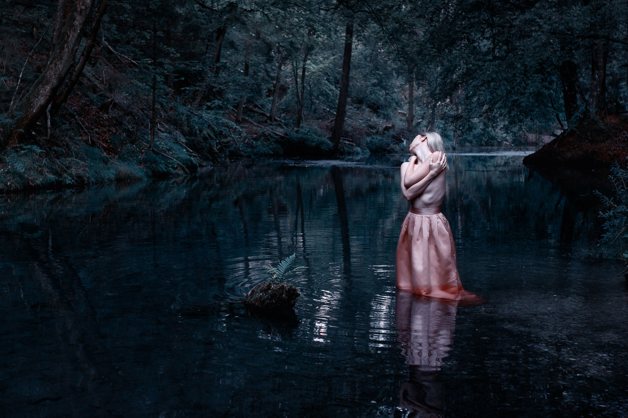 DIGITAL COMPOSITE IMAGE OF WOMAN STANDING BY WATER