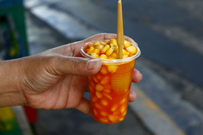 Close-up of hand holding orange