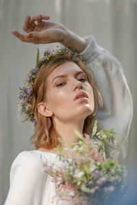 Portrait of beautiful young woman with red flower