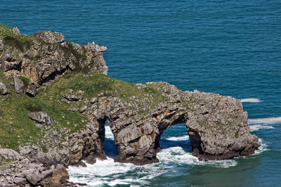 High angle view of arch shaped rocks on sea shore