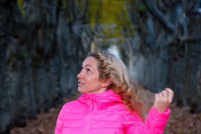 Woman looking at camera while standing outdoors