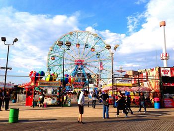 Ferris wheel at amusement park against sky