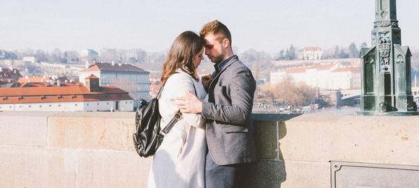 Young couple standing on sidewalk in city