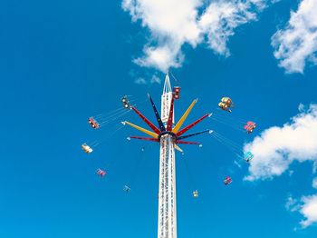 Low angle view of chain swing ride against blue sky