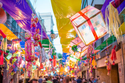 Low angle view of multi colored umbrellas hanging at market