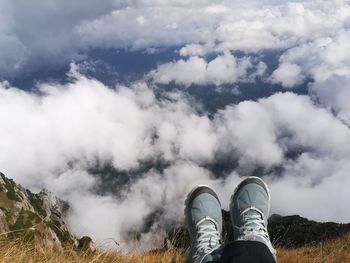 Low section of person standing on land against sky