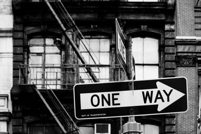 Low angle view of road sign against building