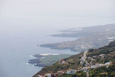 High angle view of buildings by sea against sky