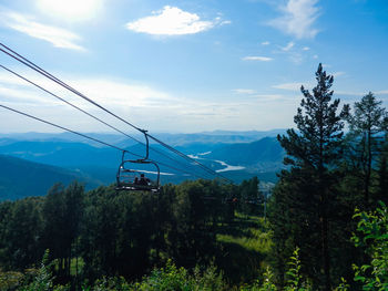Overhead cable car over mountains against sky