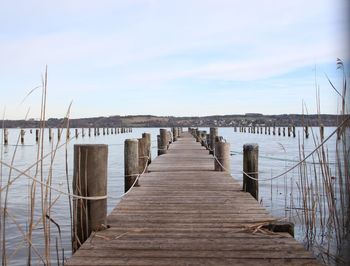 Wooden pier over sea against sky