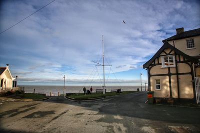 Houses by sea against sky