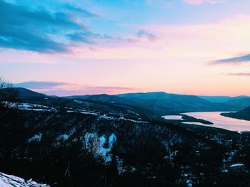 Scenic view of snowcapped mountains against sky during sunset