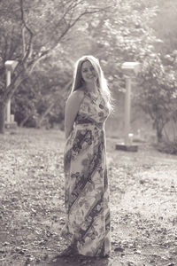 Portrait of smiling woman standing against trees