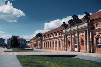 Buildings in town against cloudy sky