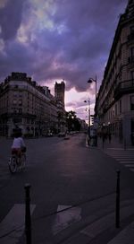 View of city street against cloudy sky