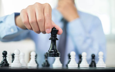 Midsection of man playing chess