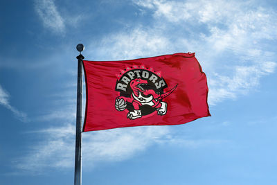 Low angle view of flag against blue sky