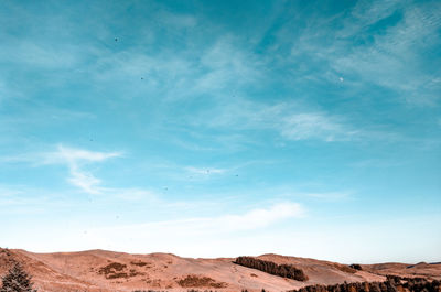 Scenic view of desert against blue sky