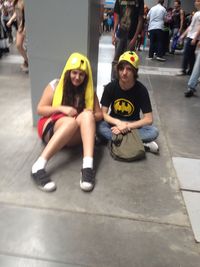 Full length portrait of friends sitting in city