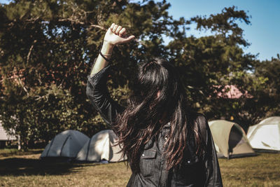 Midsection of woman with arms raised in park