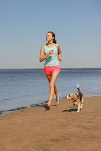 Side view of woman with dog at beach