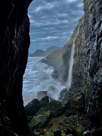 Scenic view of waterfall against sky