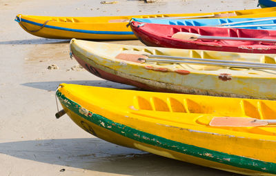 Close-up of yellow boat moored on beach