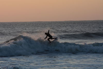 Man surfing in sea against clear sky