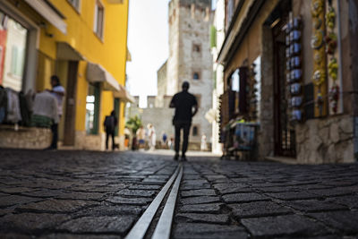 Rear view of man walking on street in city