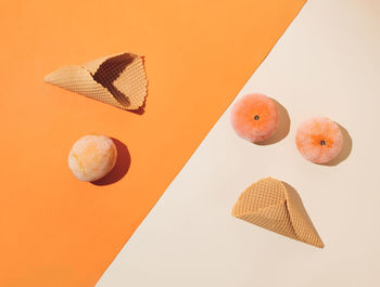 Ice cream cones with frozen summer fruit on orange and beige background. minimal summer food concept