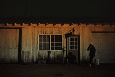 People standing outside building at night