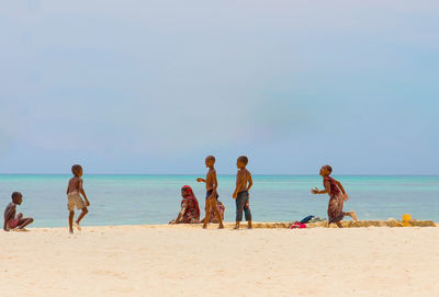 People on beach against sky