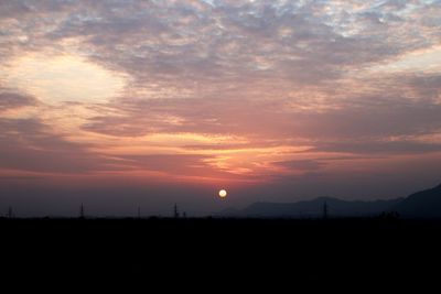 Scenic view of silhouette field against sky during sunset