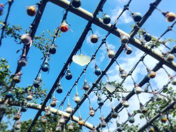 Low angle view of chainlink fence against blue sky