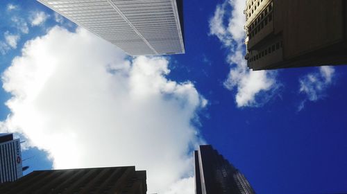 Low angle view of modern building against cloudy sky