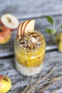 Close-up of food in jar amidst apples on table