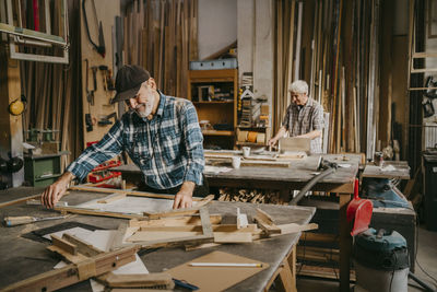 Senior craftsman preparing frame on workbench at repair shop