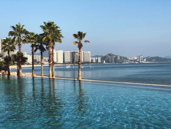 Scenic view of swimming pool by building against sky